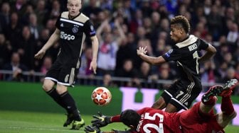 Pemain depan Ajax David Neres mencetak gol usai melawan kiper Real Madrid Thibaut Courtois pada pertandingan leg kedua babak 16 besar Liga Champions antara Real Madrid melawan Ajax Amsterdam di Stadion Santiago Bernabeu, Madrid, Spanyol, Rabu (6/3) dini hari WIB. [JAVIER SORIANO / AFP]
