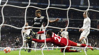 Pemain depan Ajax David Neres mencetak gol setelah melewati kiper Real Madrid Thibaut Courtois pada pertandingan leg kedua babak 16 besar Liga Champions antara Real Madrid melawan Ajax Amsterdam di Stadion Santiago Bernabeu, Madrid,  Spanyol, Rabu (6/3) dini hari WIB. [JAVIER SORIANO / AFP]