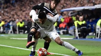 Bek Ajax Nicolas Tagliafico bersaing untuk mendapatkan bola dengan pemain tengah Real Madrid Casemiro pada pertandingan leg kedua babak 16 besar Liga Champions antara Real Madrid melawan Ajax Amsterdam di Stadion Santiago Bernabeu, Madrid, Spanyol, Rabu (6/3) dini hari WIB. [JAVIER SORIANO / AFP]