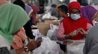 Ratusan warga melakukan pelipatan kertas suara pilpres di Gudang KPU, Cibinong, Kabupaten Bogor, Jawa Barat, Kamis (7/3). [Suara.com/Arief Hermawan P]