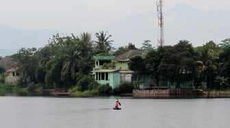 Nelayan menjaring ikan di Setu Cikaret, Cibinong, Kabupaten Bogor, Jawa Barat, Kamis (7/3). [Suara.com/Arief Hermawan P]