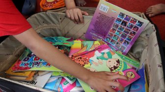 Sejumlah anak membaca buku - buku yang disediakan Perpustakaan Keliling di Kantor DPP Partai Gerindra di Jakarta, Sabtu (9/3). [Suara.com/Arief Hermawan P]