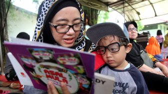 Sejumlah anak membaca buku - buku yang disediakan Perpustakaan Keliling di Kantor DPP Partai Gerindra di Jakarta, Sabtu (9/3). [Suara.com/Arief Hermawan P]