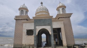 Warga melihat kondisi masjid terapung yang rusak akibat gempa dan gelombang tsunami di Pantai Kampung Lere, Palu, Sulawesi Tengah, Sabtu (9/3). ANTARA FOTO/Mohamad Hamzah