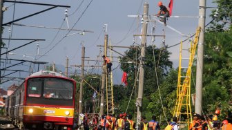 Pekerja memperbaiki jaringan Listrik Aliran Atas (LAA) pascakecelakaan KRL di kawasan Kebon Pedes, Bogor, Jawa Barat, Senin (11/3). [ANTARA FOTO/Yulius Satria Wijaya]