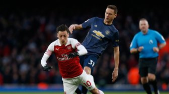 
Gelandang Arsenal Mesut Ozil dihalau oleh pemain tengah Manchester United Nemanja Matic pertandingan sepak bola Liga Primer Inggris antara Arsenal melawan Manchester United di Stadion Emirates, London, Inggris, Minggu (10/3). [Ian KINGTON / IKIMAGES / AFP]