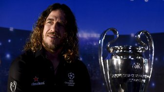 Pesepak bola legenda FC Barcelona Carles Puyol berpose di dekat trofi Liga Champions saat mengikuti UEFA Champions League Thropy Tour di Jakarta, Senin (11/3). [ANTARA FOTO/Hafidz Mubarak A]