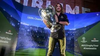 Pesepak bola legenda FC Barcelona Carles Puyol berpose di dekat trofi Liga Champions saat mengikuti UEFA Champions League Thropy Tour di Jakarta, Senin (11/3). [ANTARA FOTO/Hafidz Mubarak A]