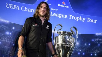 Pesepak bola legenda FC Barcelona Carles Puyol berpose di dekat trofi Liga Champions saat mengikuti UEFA Champions League Thropy Tour di Jakarta, Senin (11/3). [ANTARA FOTO/Hafidz Mubarak A]