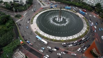 Kendaraan melintas di sekitar Bundaran Hotel Indonesia (HI), Jakarta, Selasa (12/3). [Suara.com/Arief Hermawan P.]