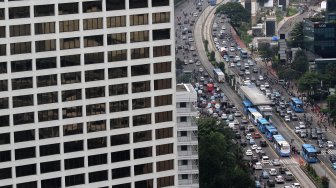 Kendaraan melintas di sekitar Bundaran Hotel Indonesia (HI), Jakarta, Selasa (12/3). [Suara.com/Arief Hermawan P.]