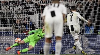 Penyerang  Juventus Cristiano Ronaldo menendang penalti dan mencetak gol ke 3 pada pertandingan leg kedua babak 16 besar Liga Champions antara Juventus melawan Atletico Madrid  di Allianz Stadium, Turin, Italia, Rabu (13/3) dini hari WIB.  [Marco BERTORELLO / AFP]