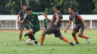 Pemain Timnas Indonesia U-23 berebut bola dengan pemain Semen Padang dalam laga uji coba di Stadion Madya, Kompleks Gelora Bung Karno, Senayan, Jakarta, Selasa (12/3). [Suara.com/Muhaimin A Untung]