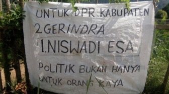 Caleg Tak Punya Modal Ini Bikin Spanduk Pakai Karung Beras