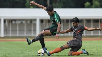 Pemain Timnas Indonesia U-23 Hanif Sjahbandi berebut bola dengan pemain Semen Padang Leo Guntara dalam laga uji coba di Stadion Madya, Kompleks Gelora Bung Karno, Senayan, Jakarta, Selasa (12/3). [Suara.com/Muhaimin A Untung]