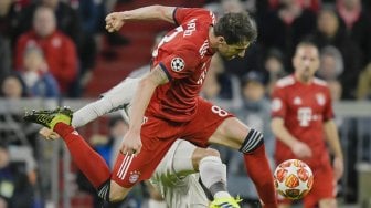 Pemain Bayern Munchen Javi Martinez dan pemain depan Liverpool bersaing untuk merebut bola selama pertandingan leg kedua babak 16 besar Liga Champions antara Bayern Munchen melawan Liverpool di Allianz Arena, Munich, Jerman, Kamis (14/3) dini hari WIB. [SCHENFMANN GUENTER / AFP]