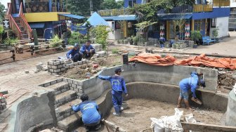 Petugas Dinas Sumber Daya Air DKI Jakarta menyelesaikan pembangunan Taman Robika di Pintu Air Manggarai, Jakarta, Kamis (14/3). [Suara.com/Muhaimin A Untung]