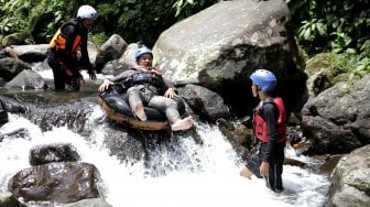 Wisatawan menikmati wisata tubing atau menyusuri sungai memanfaatkan ban dalam mobil yang digelar Sukabumi Getlost di Sungai Cipelang, Sukabumi, Jawa Barat, Kamis (14/3). ANTARA FOTO/Budiyanto