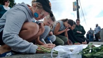 Warga menulis pesan di dekat bunga yang diletakkan di depan Masjid Wellington, Kilbirnie, Wellington, Selandia Baru, Sabtu (16/3). ANTARA FOTO/Ramadian Bachtiar