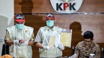 Wakil Ketua KPK Laode M. Syarief bersama penyidik menunjukkan barang bukti hasil OTT kasus dugaan suap terkait seleksi pengisian jabatan pimpinan tinggi di Kementerian Agama saat konferensi pers di gedung KPK, Jakarta, Sabtu (16/3). [Suara.com/Muhaimin A Untung]