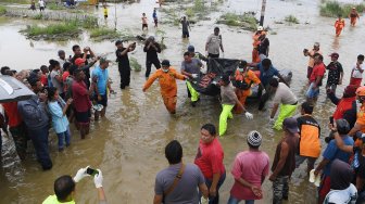 Tim SAR Gabungan mendorong perahu karet yang memuat jenazah korban banjir bandang Sentani yang di temukan di sekitar perumahan Gajah Mada di Sentani, Jaya Pura, Papua, Selasa (19/3). [ANTARA FOTO/Zabur Karuru]