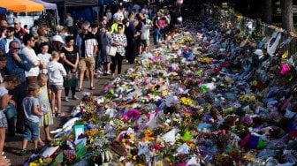 Para warga kota Christchurch meletakan bunga di dinding depan Botanical Garden, Selandia Baru, Selasa (19/3).  [Marty MELVILLE / AFP]