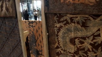 Pengunjung memperhatikan beragam produk batik dan tenun di sejumlah stan pada pameran Adiwastra di JCC, Jakarta, Sabtu (23/3).  [Suara.com/Arief Hermawan P]