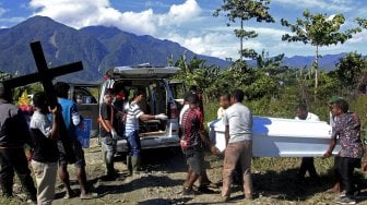 Keluarga duka mengangkat peti yang berisi jenazah korban banjir bandang Sentani ke dalam mobil jenazah untuk dimakamkan di Sentani, Jayapura, Papua, Sabtu (23/3).  [ANTARA FOTO/Zabur Karuru]