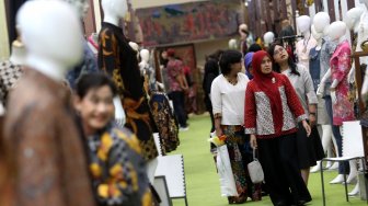 Pengunjung memperhatikan beragam produk batik dan tenun di sejumlah stan pada pameran Adiwastra di JCC, Jakarta, Sabtu (23/3).  [Suara.com/Arief Hermawan P]