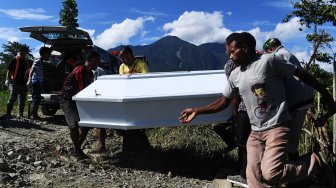 Keluarga duka mengangkat peti yang berisi jenazah korban banjir bandang Sentani ke dalam mobil jenazah untuk dimakamkan di Sentani, Jayapura, Papua, Sabtu (23/3).  [ANTARA FOTO/Zabur Karuru]