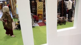 Pengunjung memperhatikan beragam produk batik dan tenun di sejumlah stan pada pameran Adiwastra di JCC, Jakarta, Sabtu (23/3).  [Suara.com/Arief Hermawan P]