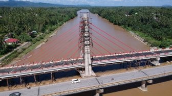 Sejumlah kendaraan melintasi Jembatan Sungai Dareh lama di samping Jembatan Sungai Dareh baru yang masih dalam proses pembangunan di Jalan Lintas Sumatera Sumbar-Jambi, Pulau Punjung, Dharmasraya, Sumatera Barat, Sabtu (30/3). ANTARA FOTO/Wahdi Septiawan