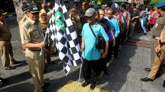 Sejumlah penyandang disabilitas membentuk regu iring - iringan menyusuri ubin pemandu yang dikhususkan bagi disabilitas netra di kawasan Blok M, Jakarta Selatan, Jakarta, Selasa (2/4). [Suara.com/Arief Hermawan P]