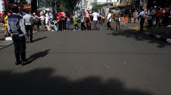 Sejumlah penyandang disabilitas membentuk regu iring - iringan menyusuri ubin pemandu yang dikhususkan bagi disabilitas netra di kawasan Blok M, Jakarta Selatan, Jakarta, Selasa (2/4). [Suara.com/Arief Hermawan P]