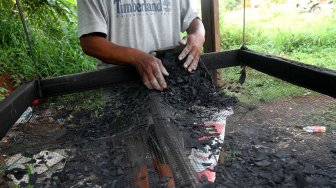 Pekerja melakukan proses pembuatan arang batok di kawasan Krukut, Depok, Jawa Barat, Rabu (3/4). [Suara.com/Arief Hermawan P]