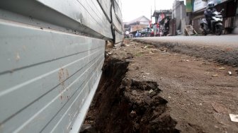 Kendaraan melintasi tembok yang roboh di Jalan Kebagusan Raya, Jakarta Selatan, Kamis (4/4). [Suara.com/Arief Hermawan P]