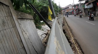 Kendaraan melintasi tembok yang roboh di Jalan Kebagusan Raya, Jakarta Selatan, Kamis (4/4). [Suara.com/Arief Hermawan P]