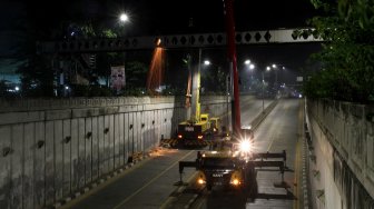 Suasana perobohan Jembatan Penyeberangan Orang (JPO) di depan Stasiun Pasar Minggu, Jakarta, Sabtu (6/4) dini hari. [Suara.com/Arief Hermawan P]