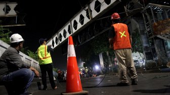 Suasana perobohan Jembatan Penyeberangan Orang (JPO) di depan Stasiun Pasar Minggu, Jakarta, Sabtu (6/4) dini hari. [Suara.com/Arief Hermawan P]