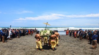 Sejumlah abdi dalem Keraton Yogyakarta membawa sesaji menuju pantai saat Prosesi Labuhan Parangkusumo di Pantai Parang Kusumo, Bantul, DI Yogyakarta, Sabtu (6/4).  [ANTARA FOTO/Andreas Fitri Atmoko]