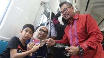 Deputy CEO Smartfren Djoko Tata Ibrahim dan VP Technology Relations and Special Project Smartfren Munir Syahda Prabowo mensosialisasikan kepada warga penggunaan kartu smartfren di MRT jakarta, Selasa (9/4). [Suara.com/Muhaimin A Untung]