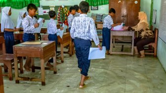 Sejumlah siswa SD kelas VI mengikuti ujian sekolah di ruang kelas yang terendam banjir di SD Negeri Sayung 4, Sayung, Demak , Jawa Tengah, Rabu (10/9). [ANTARA FOTO/Aji Styawan]