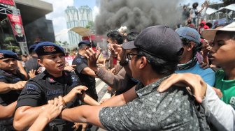 Massa yang mengatasnamakan dari Aliansi Pemuda Pengawas KPK terlibat bentrok dengan polisi saat berunjuk rasa di depan Gedung KPK, Jakarta, Kamis (11/4). [Suara.com/Muhaimin A Untung]