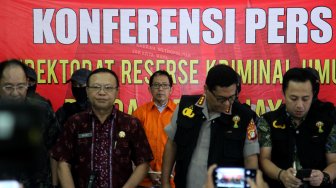 Mantan Plt Ketua Umum PSSI, Joko Driyono (mengenakan rompi) digiring petugas sebelum meninggalkan Polda Metro Jaya, Jakarta, Jumat (12/4). [Suara.com/Arief Hermawan P]
