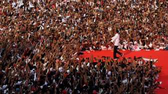 Capres nomor urut 01 Joko Widodo menyapa pendukung saat kampanye akbar bertajuk "Konser Putih Bersatu" di Jakarta, Sabtu (13/4).[Suara.com/Arief Hermawan P]