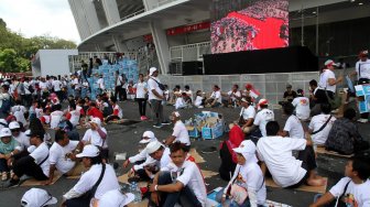 Pendukung pasangan Capres-Cawapres nomor urut 01 di Gelora Bung Karno (GBK) sesaat sebelum kampanye akbar bertajuk "Konser Putih Bersatu" di Jakarta, Sabtu (13/4). [Suara.com/Arief Hermawan P]