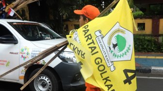 Sejumlah petugas PPSU menurunkan Alat Peraga Kampanye (APK) peserta Pemilu di Kawasan Imam Bonjol, Jakarta, Minggu (14/4). [Suara.com/Muhaimin A Untung]