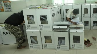 Petugas mengecek kotak suara berisi logistik di Kecamatan Menteng, Jakarta, Senin (15/4). [Suara.com/Muhaimin A Untung]