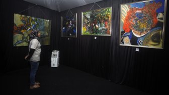 Pengunjung mengamati sejumlah lukisan karya penyanyi dan pencipta lagu Iwan Fals saat pembukaan pameran di Galeri Suara Hati, Depok, Jawa Barat, Senin (15/4). [FOTO/Yulius Satria Wijaya]
