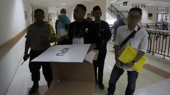 Seorang pasien menggunakan hak pilihnya di TPS 034, RSCM, Rabu (17/4). [Suara.com/Muhaimin A Untung]
